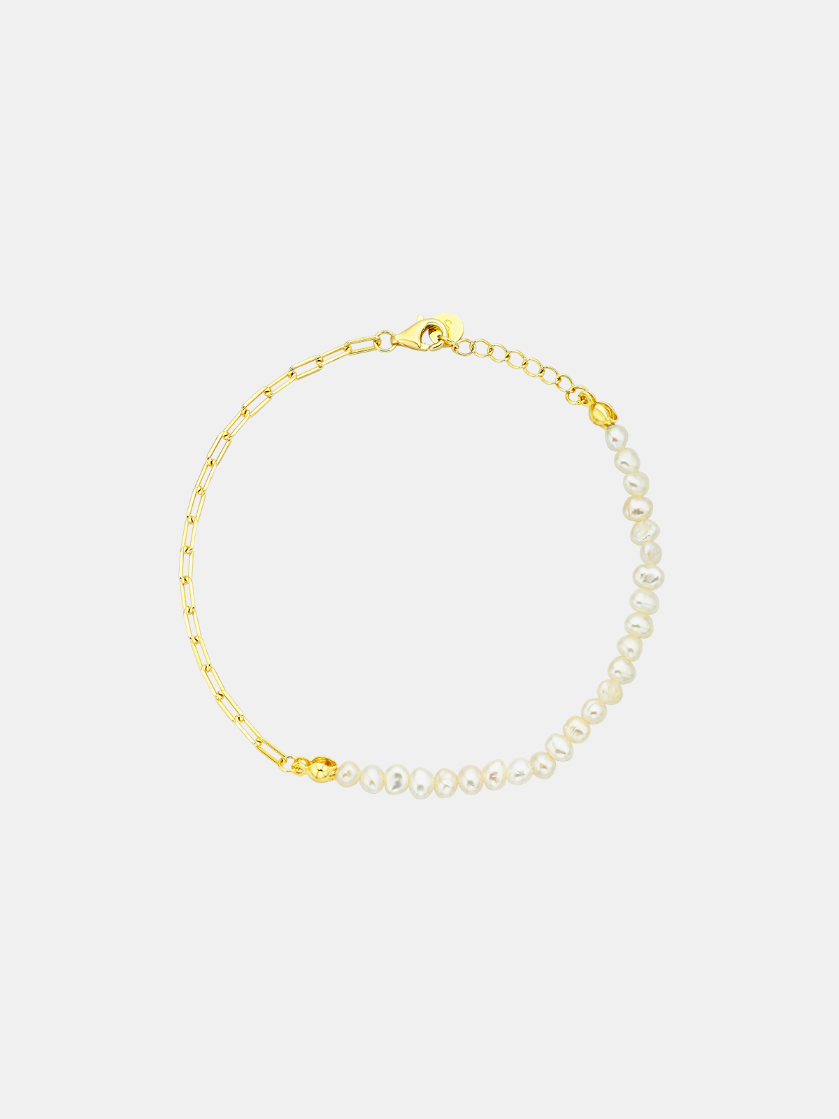 Gold bracelet with pearl accents on a light gray background