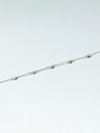 Delicate silver chain bracelet on a light gray background
