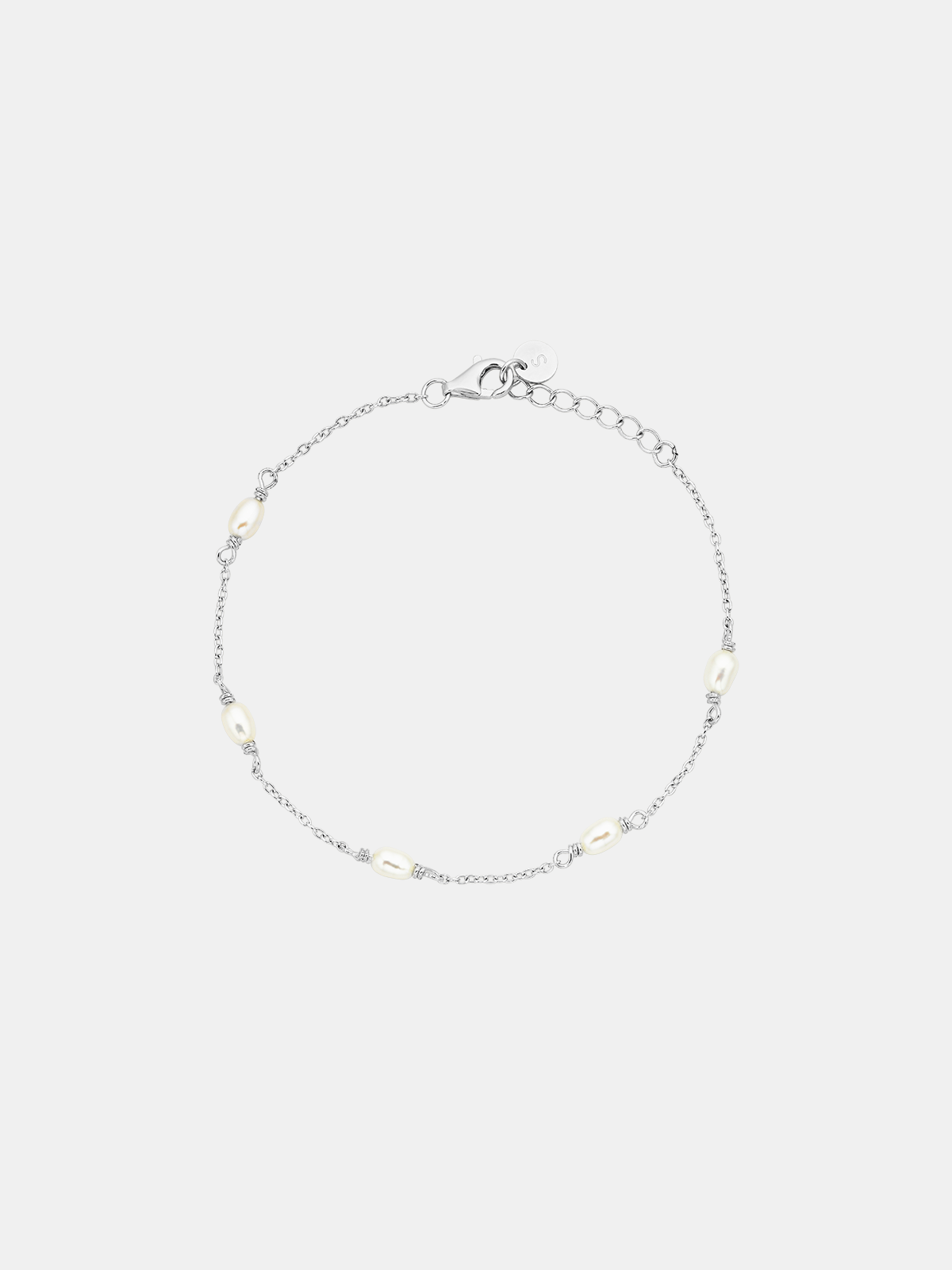Silver bracelet with small beads on a light gray background