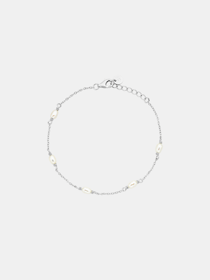 Silver bracelet with small beads on a light gray background