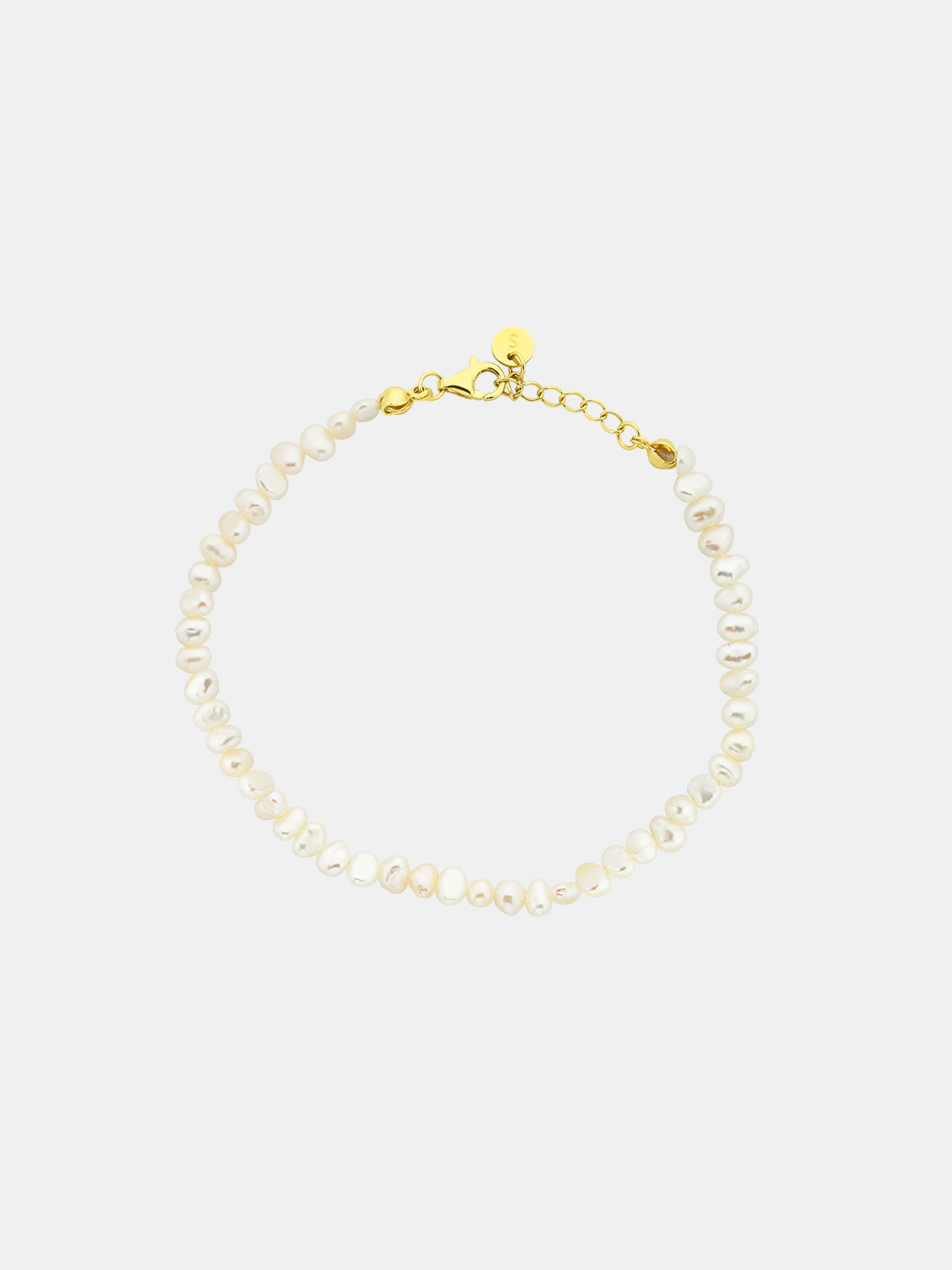 Pearl anklet with gold clasp on a white background