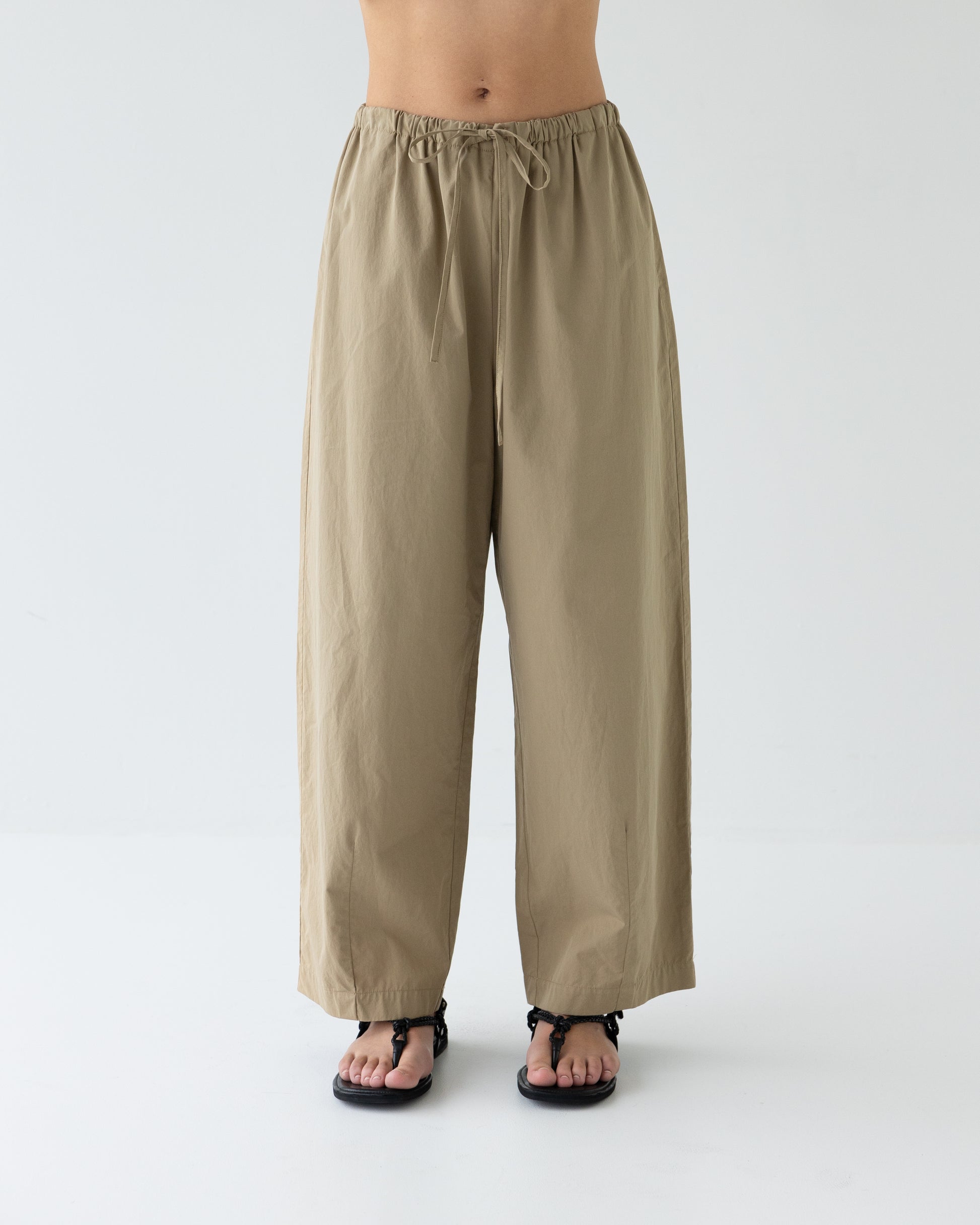 Beige wide-leg pants worn by a person on a white background