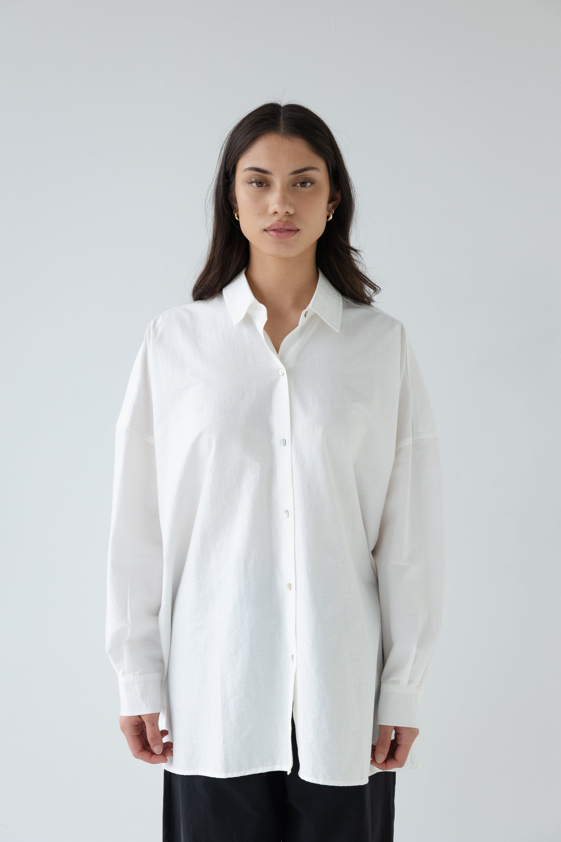 Woman wearing a white shirt against a plain background