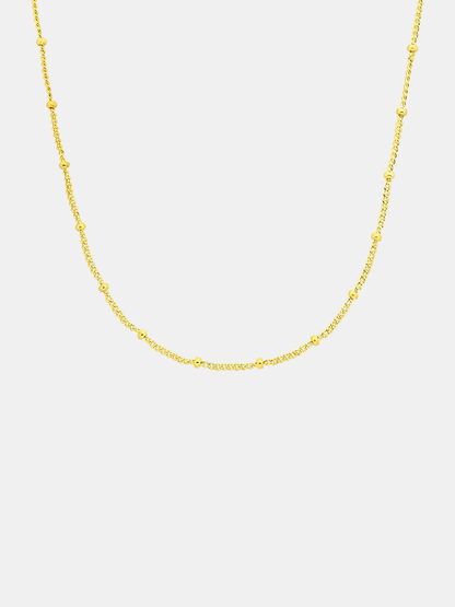 Gold chain necklace on a light gray background