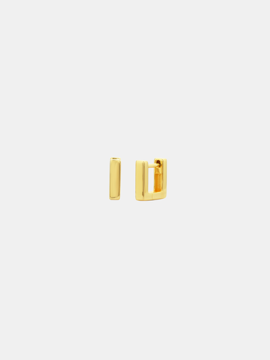 Gold hoop earrings on a light beige background