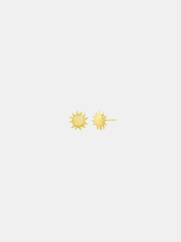 Gold sun-shaped earrings on a light gray background