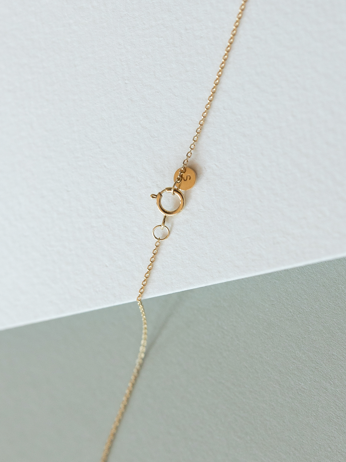 Gold clasp on a light gray background