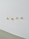 Set of solid gold letter earrings on a light gray background