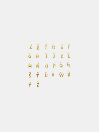 Solid gold little letter pendants on a white background