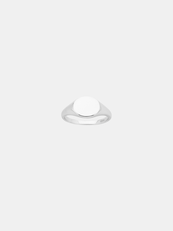 Silver signet ring on a light gray background