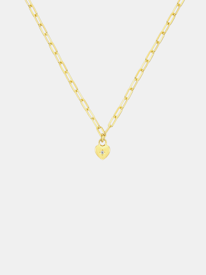 Gold necklace with a small sweetheart pendant on a light gray background