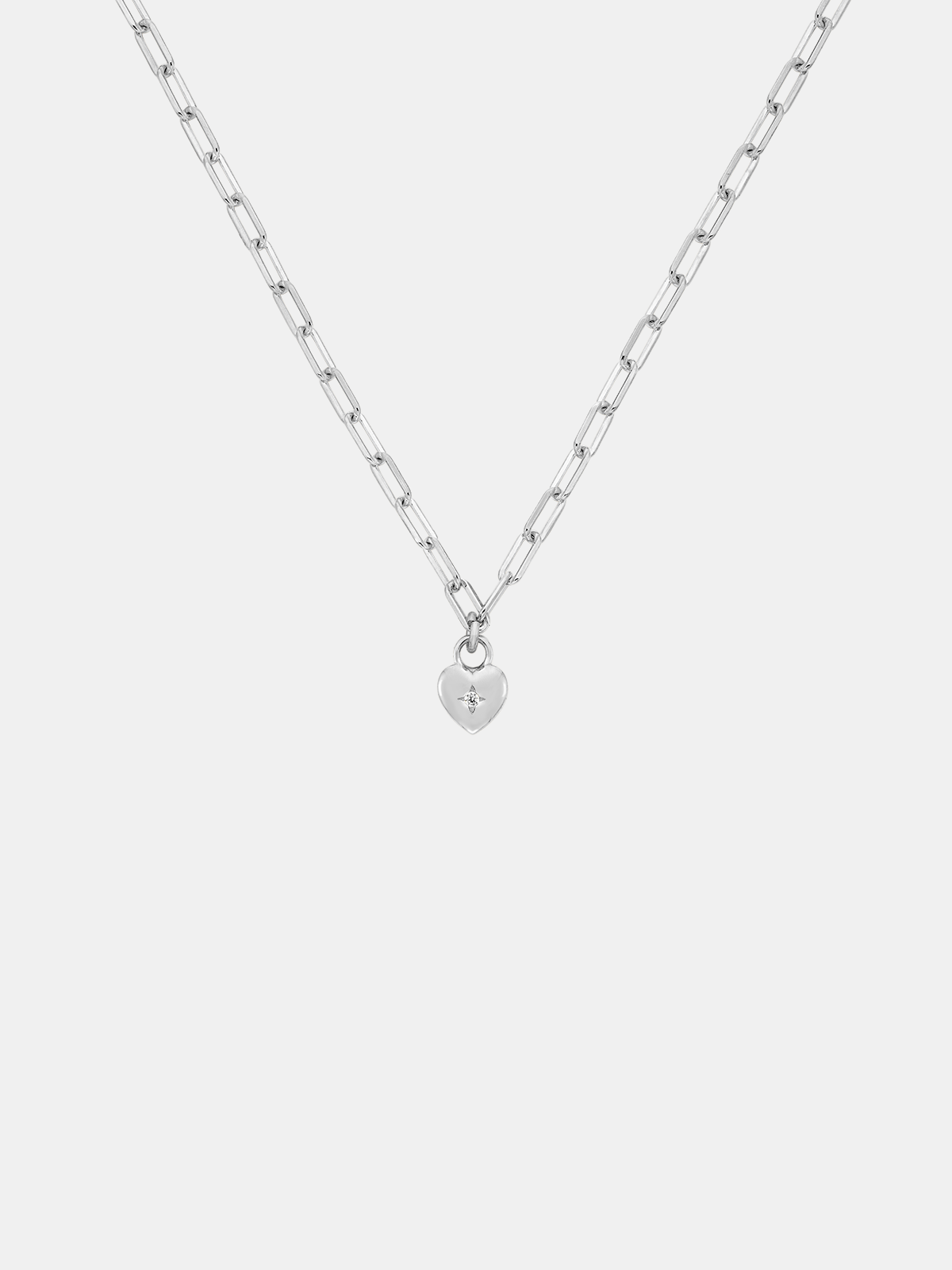 Silver necklace with a small sweetheart pendant on a light gray background