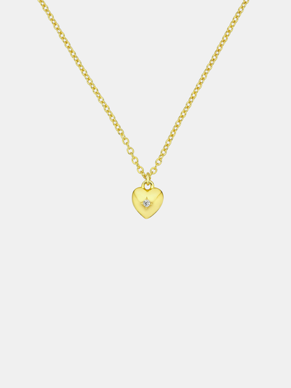 Gold heart-shaped pendant necklace on a light gray background