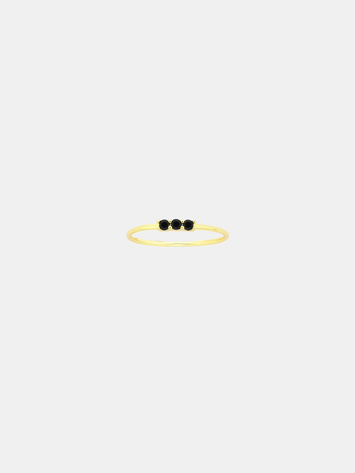 Gold ring with three black stones on a white background