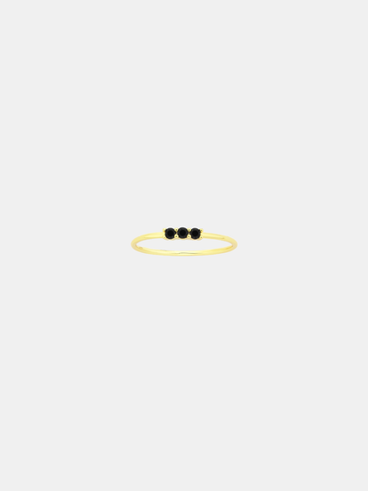 Gold ring with three black stones on a white background