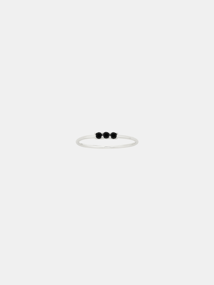 Thin silver ring with three black stones on a white background