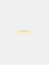 Gold ring with three stones on a light beige background