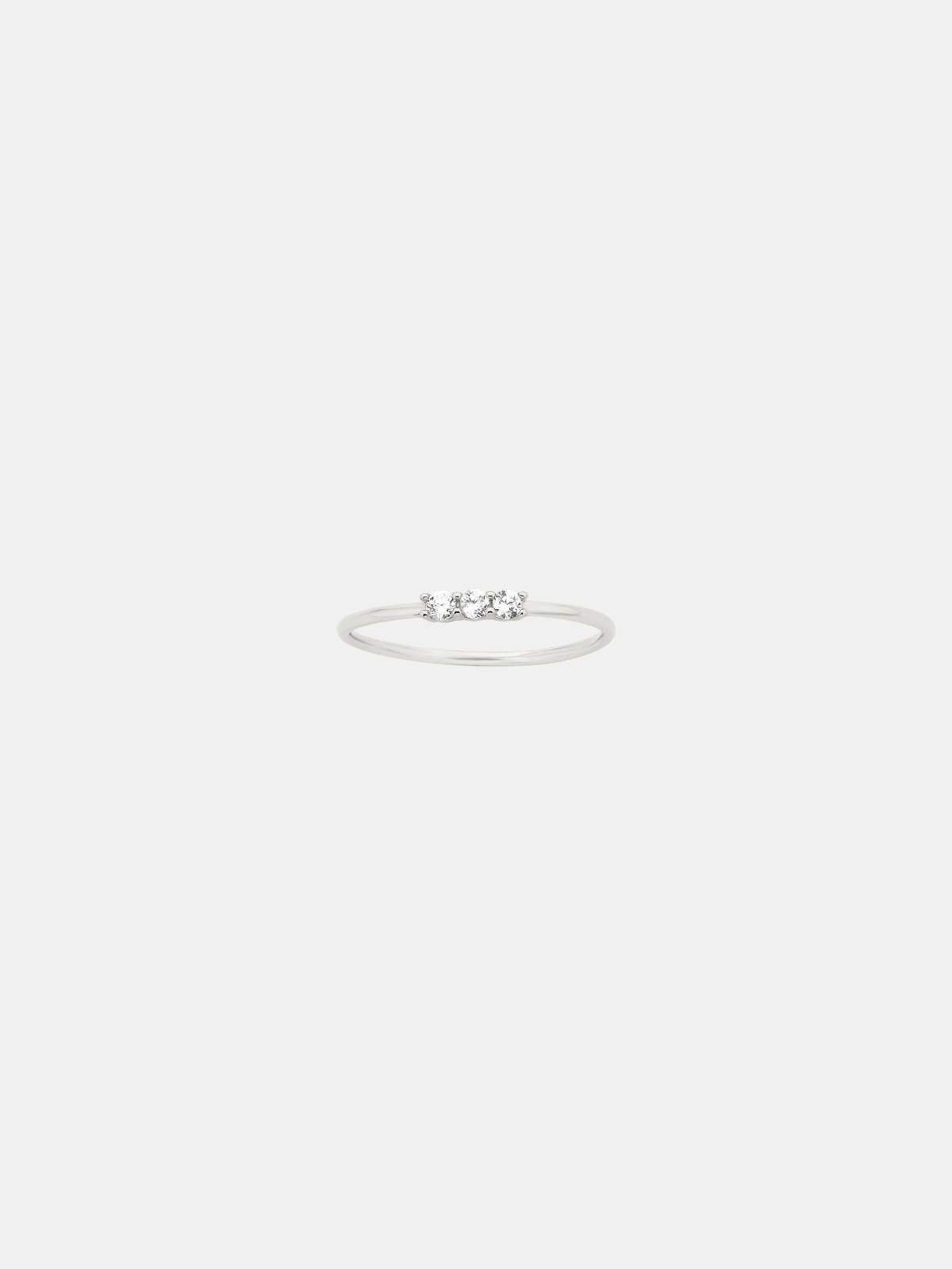 Silver ring with small stones on a light gray background