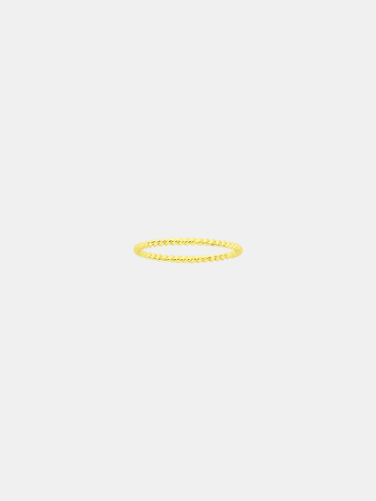 Gold twist ring on a light gray background